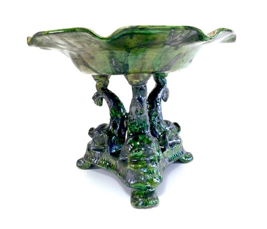 Decorative glass bowl with a base resembling trees and foliage on a white background
