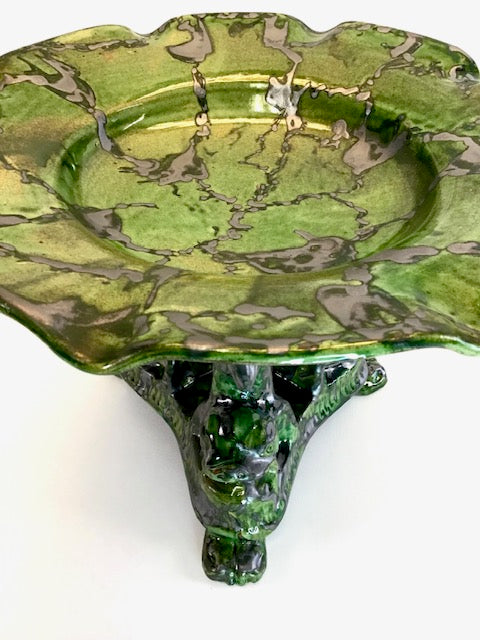 Green marble-patterned dish with a pedestal base on a white background