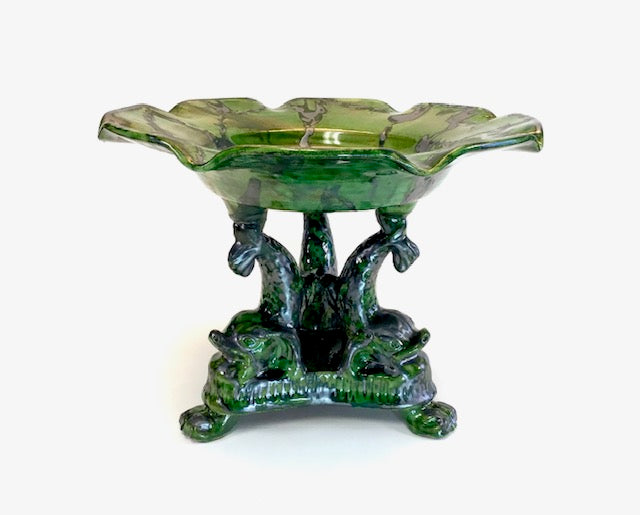 Green glass bowl with leaf-shaped rim on a white background