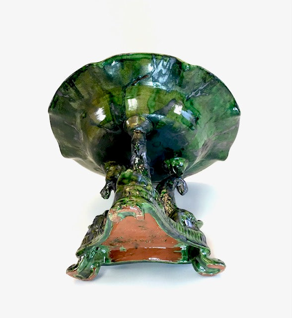Decorative green ceramic vase with leaf design on a white background