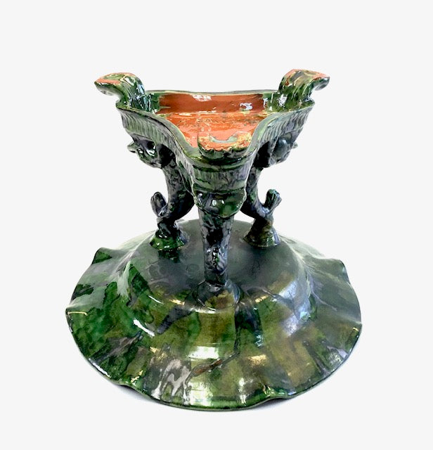 Decorative ceramic vase with green base and red interior on a white background