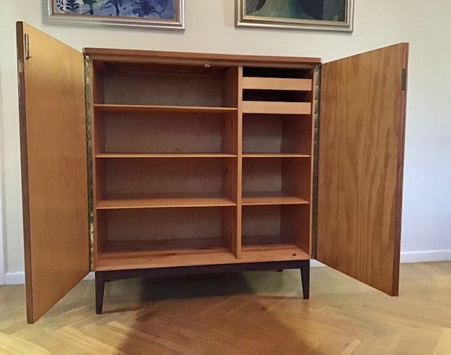 Wooden cabinet with open doors on a wooden floor