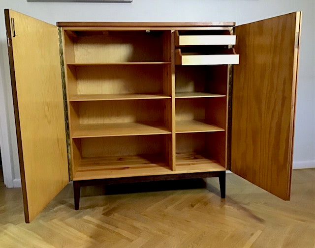 Wooden cabinet with open doors on a wooden floor