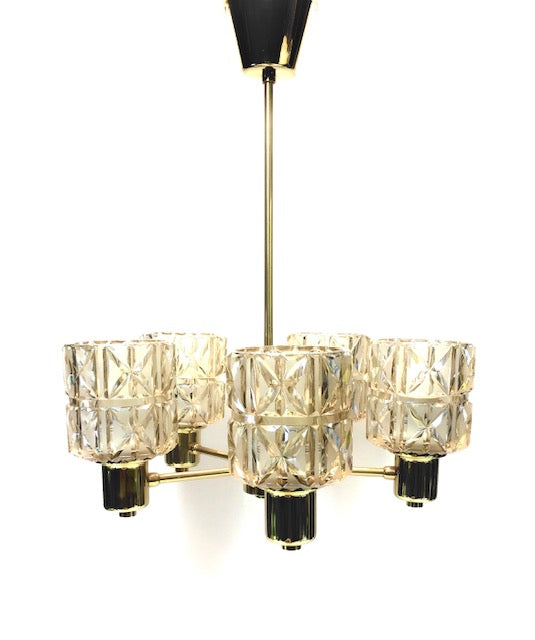 Chandelier with crystal-like glass shades and gold accents on a white background