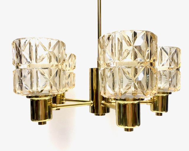 Chandelier with gold frame and clear glass shades on a white background