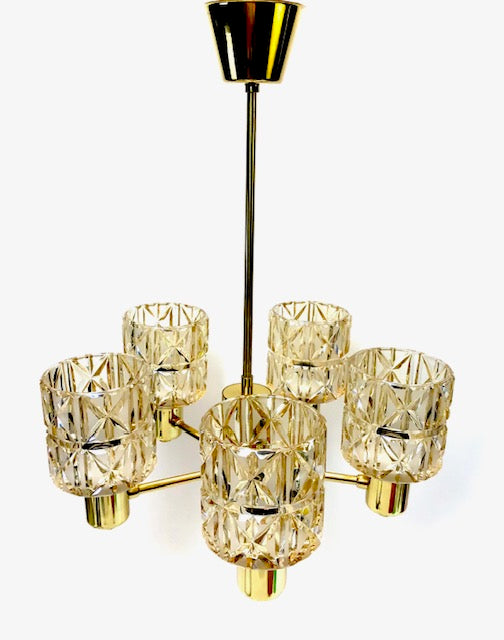 Gold chandelier with crystal-like glass shades on a white background