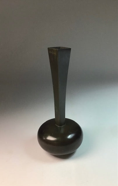 Bronze vase with a wide base and narrow neck on a gray background