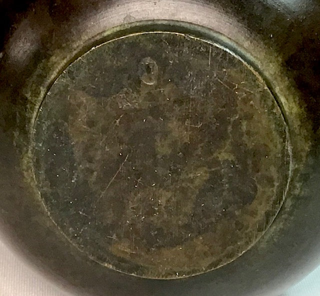 Close-up of a metallic object with a circular component showing wear and tear.