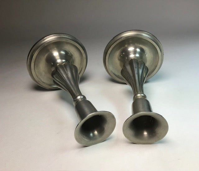 Two metallic door handles on a gray background