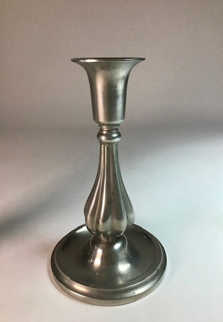 Silver candlestick holder on a light gray background