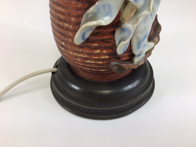Decorative lamp with a ceramic base and figurine on a white background