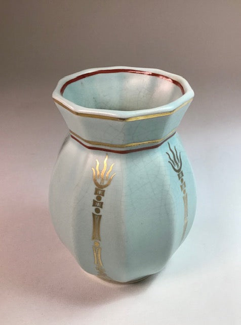 Decorative ceramic vase with gold accents on a gradient background