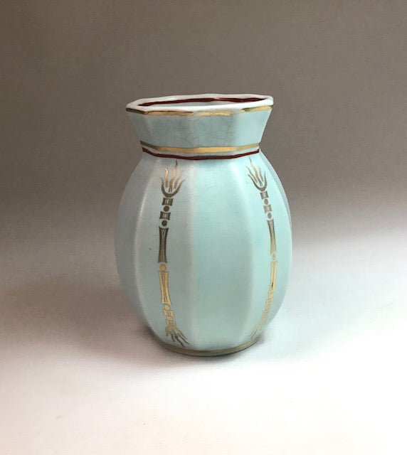 Ceramic vase with gold accents on a neutral background