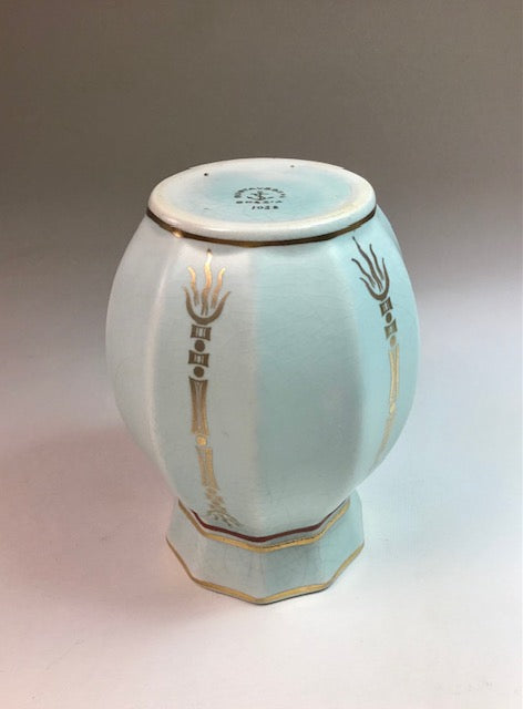 Decorative ceramic vase with gold accents on a gradient background