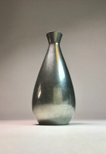 Silver metallic vase on a gray background