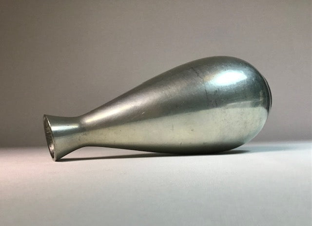 Metallic bullet-shaped object on a neutral background