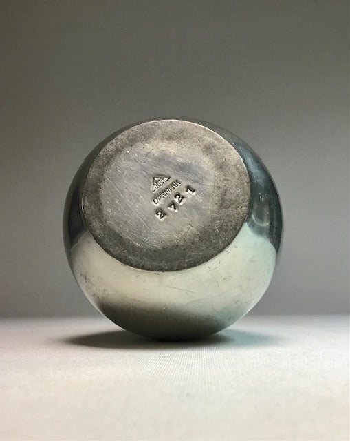 Round ceramic object with a visible brand logo on a gray background