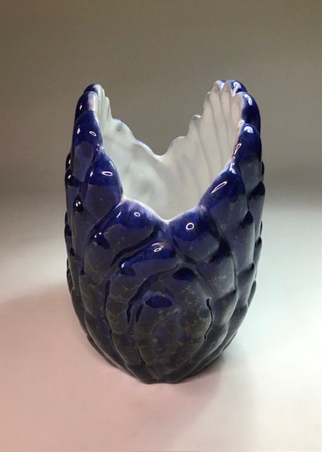 Ceramic vase with blue and white design on a plain background