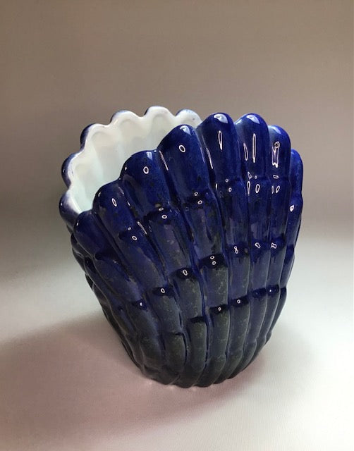 Blue glass vase with white interior on a beige background