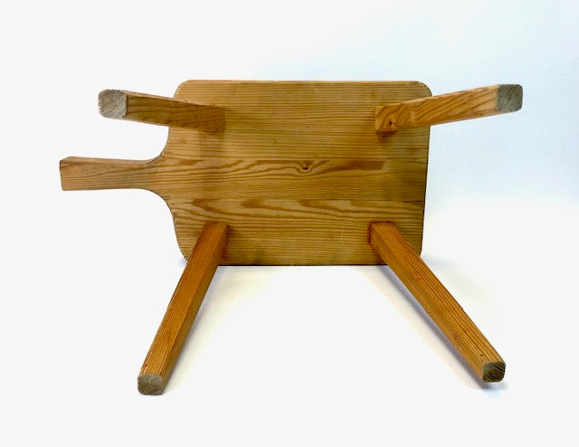Wooden stool with a flat top and four legs on a white background