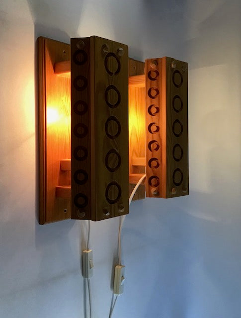 Wooden wall-mounted lamp with circular design on a white wall