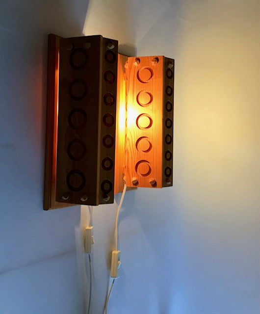 Wall-mounted light fixture designed like a LEGO brick with glowing interior