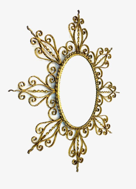 Decorative gold mirror with intricate patterns on a white background
