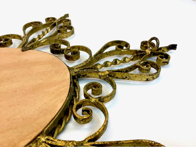 Decorative gold metal frame with intricate designs on a white background