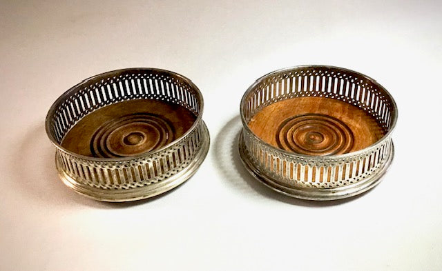 Two metallic coasters with circular designs on a light background