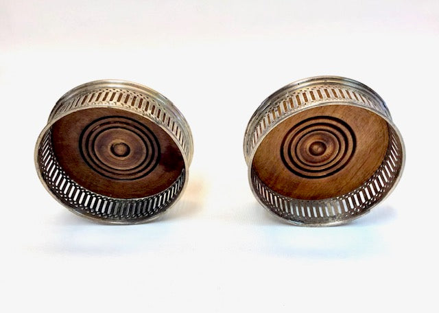 Two wooden bottle caps with metal rims on a white background