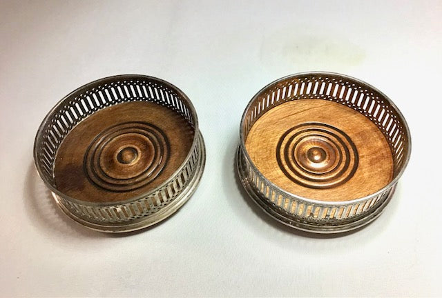 Two metallic coasters with circular designs on a white background