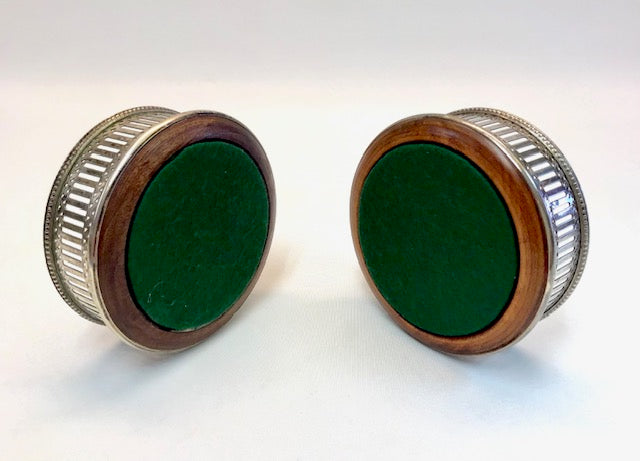Two round objects with green centers and metallic rims on a white background