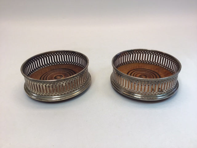 Two metallic coasters with circular designs on a white background