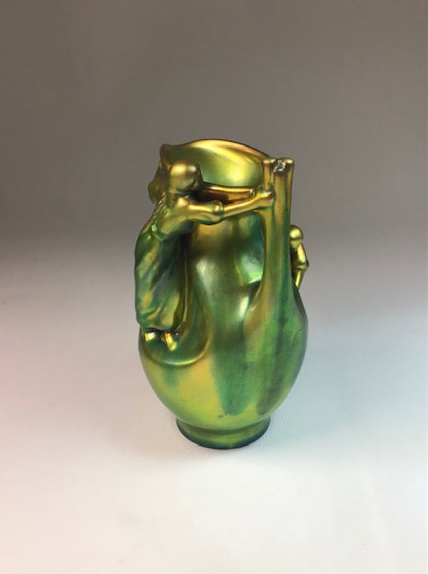 Green glass vase with abstract design on a gray background