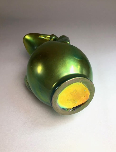 Metallic green and yellow object on a light gray background