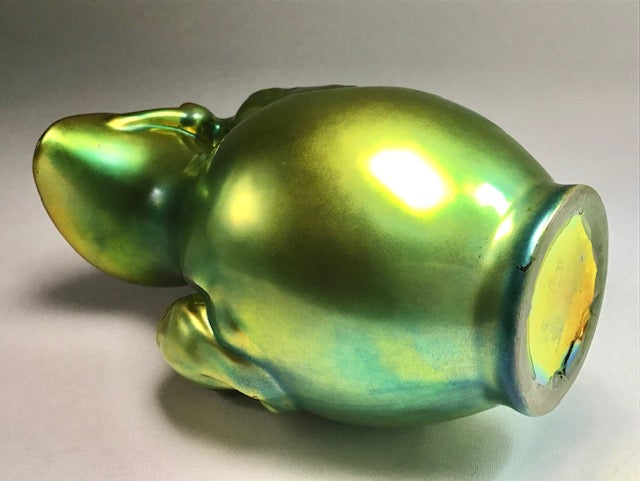 Green glass piggy bank on a gray background