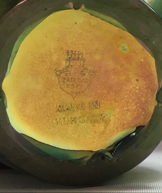 Round yellow object with 'Made in Hungary' text on a metal surface